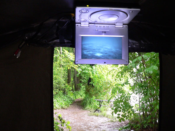 Der Bildschirm h�ngt, mit Magneten befestigt, an der Zeltdecke.